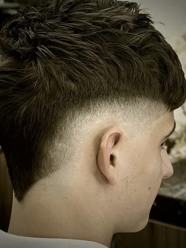 Seitenansicht eines texturierten Schnitts mit sauberem Fade – Arbeit aus dem Salon Sher