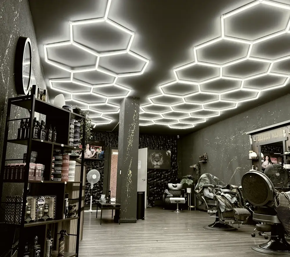 Der Salon Sher von innen: Produktregal, Barberstühle und die Wabenbeleuchtung